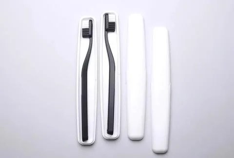 Toothbrushes and toothpaste tubes on white surface Fotos Stock
