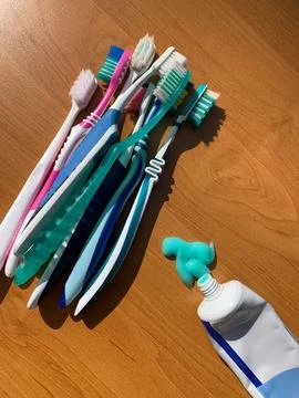 Toothbrushes and Toothpaste on Wooden Surface Stock Photos