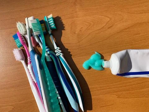 Toothbrushes and Toothpaste on Wooden Surface Stock Photos