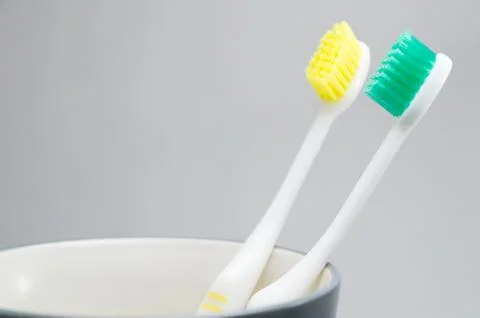 Toothbrushes in cup on white background Stock Photos
