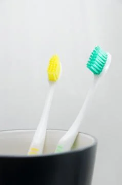 Toothbrushes in cup on white background Stock Photos