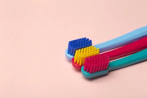 Toothbrushes of different colors on a pink background. Brushing teeth and oral Stock Photos