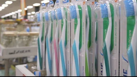 Toothbrushes in packaging on a store shelf Stock Footage 300278417
