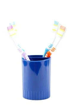 Toothbrushes in a plastic cup on a white background. Stock Photos