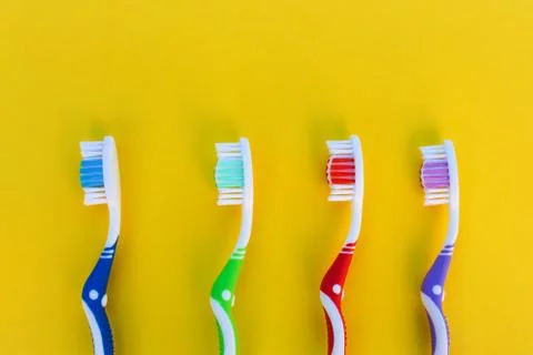 Toothbrushes on yellow background. Top view. Stock Photos