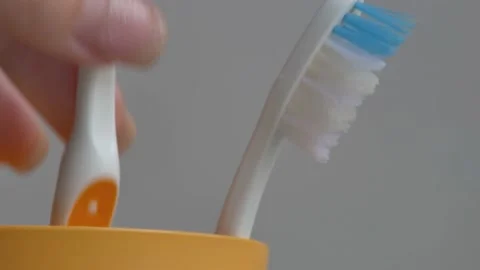 Toothbrushes in a yellow glass Stock Footage 230088540