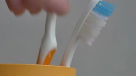 Toothbrushes in a yellow glass Stock Footage 230088543