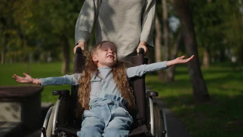 Toothless girl sits in wheelchair spread... | Stock Video | Pond5