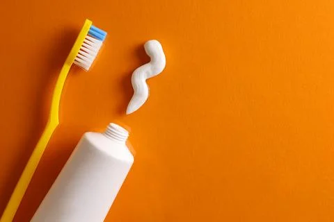 Toothpaste and toothbrush on a colored background. Dental care, oral health. Stock Photos