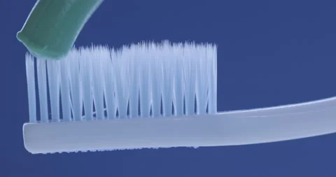 Toothpaste is applied to a toothbrush. Close up shot Stock Footage 140214019