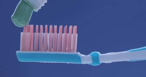 Toothpaste is applied to a toothbrush. Close up shot Stock Footage 141074435