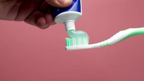 Toothpaste is applied to a toothbrush from a tube. Stock Footage 308435873