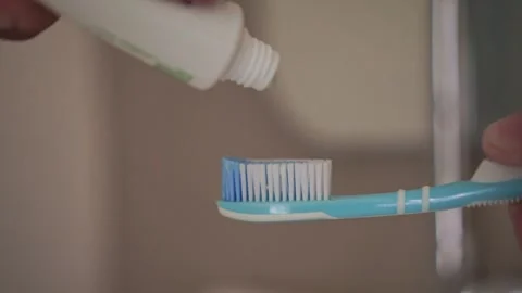 Toothpaste being applied to a toothbrush. Vídeos de archivo 337723830