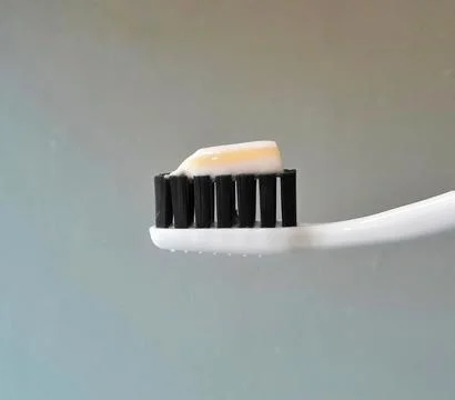 Toothpaste on a black toothbrush Stock Photos