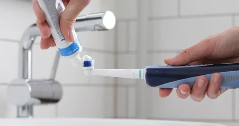 Toothpaste on electric toothbrush Video stock 86813146