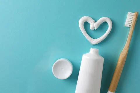 Toothpaste heart on a colored background. Dental care, oral health. Stock Photos