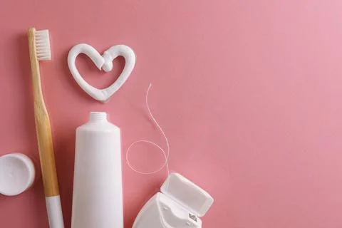 Toothpaste heart on a colored background. Dental care, oral health. Stock Photos