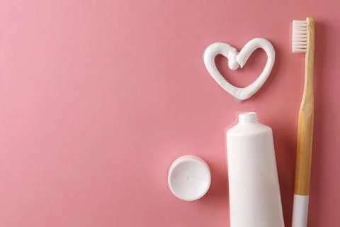 Toothpaste heart on a colored background. Dental care, oral health. Stock Photos