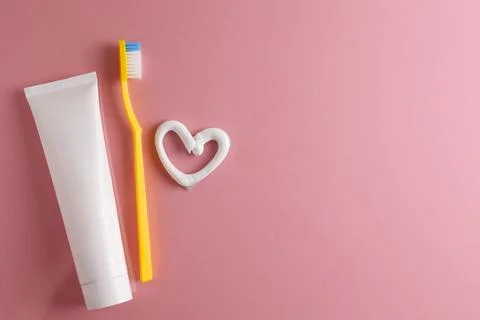 Toothpaste heart on a colored background. Dental care, oral health. Stock Photos
