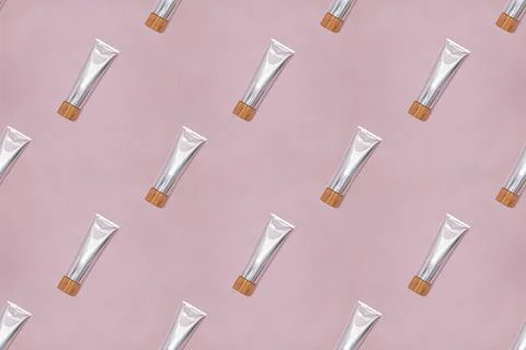 Toothpaste in metal container on pink background. Stock Photos