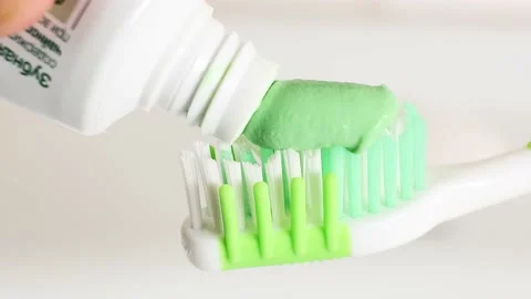 Toothpaste is smeared on a toothbrush Stock Footage 156030771