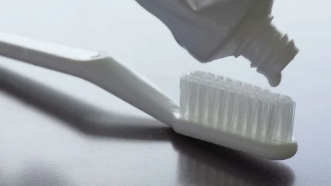 Toothpaste is squeezed on a toothbrush. Close-up footage Stock Footage 85215515