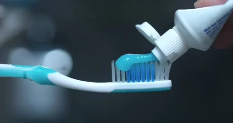 Toothpaste squeezed onto toothbrush close-up marks start of dental cleaning Stock Footage 265728575