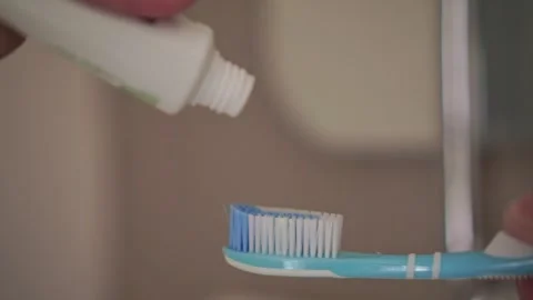Toothpaste squeezed onto a toothbrush for morning dental care. Vídeos de archivo 338427170