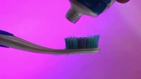 Toothpaste on Toothbrush with Bright Pink Background for Dental Care Stock Footage 295274065