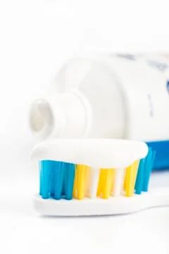 Toothpaste on toothbrush in closeup macro with toothpaste in the background Stock Photos