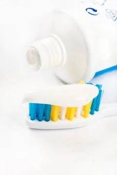 Toothpaste on toothbrush in closeup macro with toothpaste in the background Stock Photos