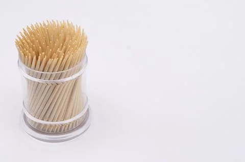 Toothpicks in Clear Plastic Container on White Background, Close-Up View. Stock Photos