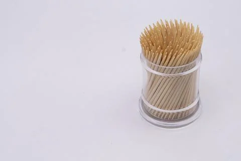 Toothpicks in a Clear Plastic Container on a White Background, Close-Up View. Stock Photos