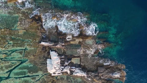Top aerial drone view of waves crashing on rocky coastline Video stock 279582076