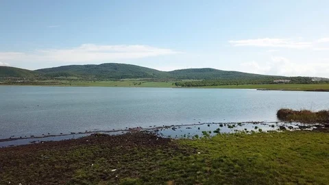 Top Aerial fast moving View Of lake and beach with wide landscape in 4K Stock Footage 108041562