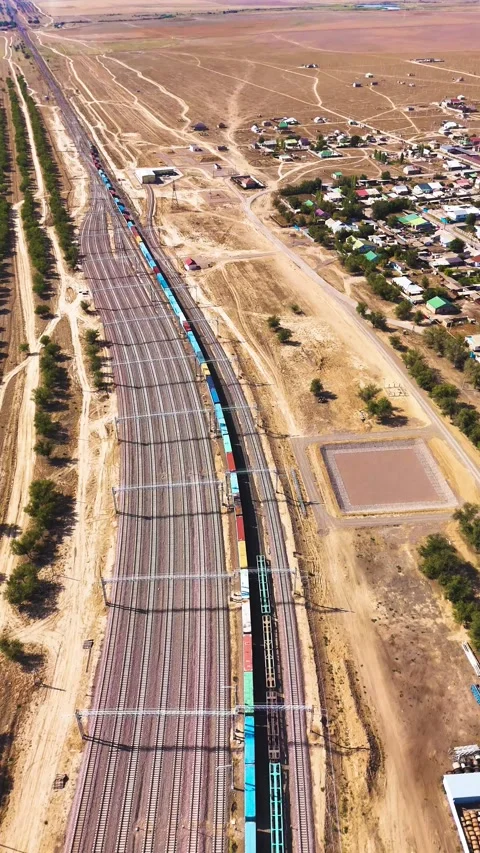 Top Aerial of Long Container Freight Train Moving Through Rail Yard Stock Footage 346320872
