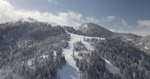 Top Aerial shot comes down slowly on the skiing slope and follows the skiers Stock Footage 125460682