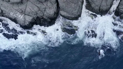Top aerial view of blue Ocean waves breaking and foaming on high cliff of a Vidéo 147976344