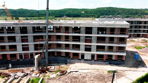 Top aerial view of a massive construction site with a house in a city Stock Footage 135165832