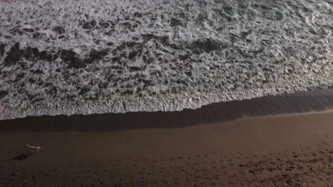 Top aerial view of ocean waves and beach. People walking on the beach. Stock Footage 159844944
