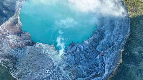 Top aerial view of turquoise sulfur water lake, surrounded by rock cliff at Stockfoto's