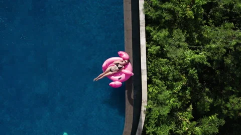 Top aerial view of young passion female tourist in bikini lies inflatable pink Stock Footage 246768460