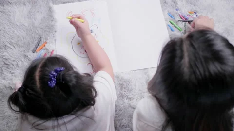 Top and back view of mom and kid lying on the floor doing painting by colour Stock Footage 163786355