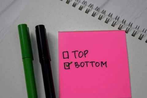 Top and Bottom write on a sticky note. Supported by an additional services Foto stock
