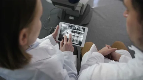 Top angle dentist looking at x-ray on touchpad Video stock 89782290