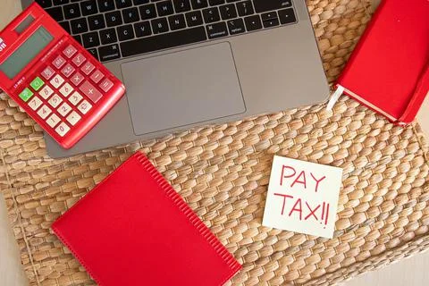 Top angle. Office concept. With hand writing Pay tax word using red marker on Stock Photos