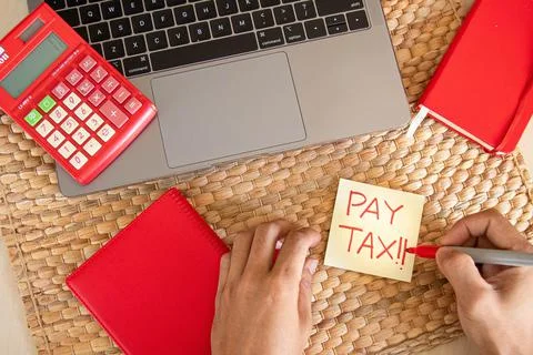 Top angle. Office concept. With hand writing Pay tax word using red marker on Stock Photos
