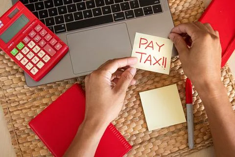 Top angle. Office concept. With hand writing Pay tax word using red marker on Stock Photos