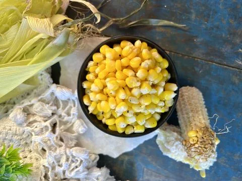 Top Angle shot of corn in a black bowl on a wooden background. Stock Photos