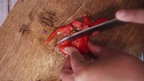 Top angle shot of tomato cutting on a wooden chopping board. Stock Footage 282766578